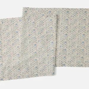 Coyuchi Coral Bell Print table runner in ivory with scattered blue floral pattern, two runners shown.