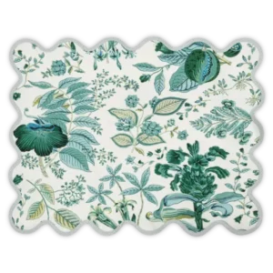 The Pomegranate Linen Placemat Set by Matouk features a scalloped edge and showcases a green and blue floral leaf pattern on white, inspired by the Schumacher Pomegranate design.