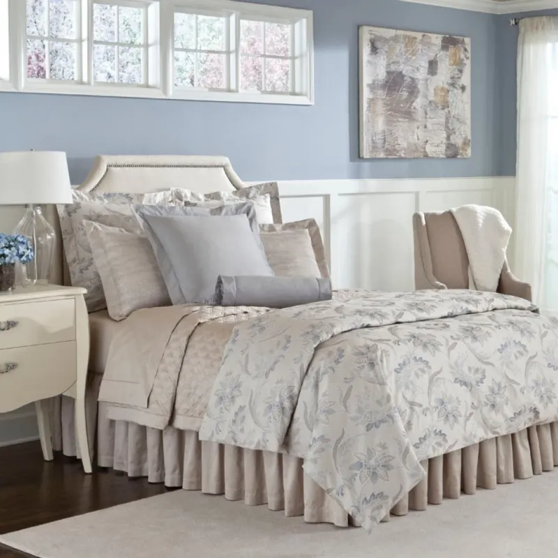 Home Treasures Fiori quilted coverlet in ivory with blue floral pattern on styled bed.