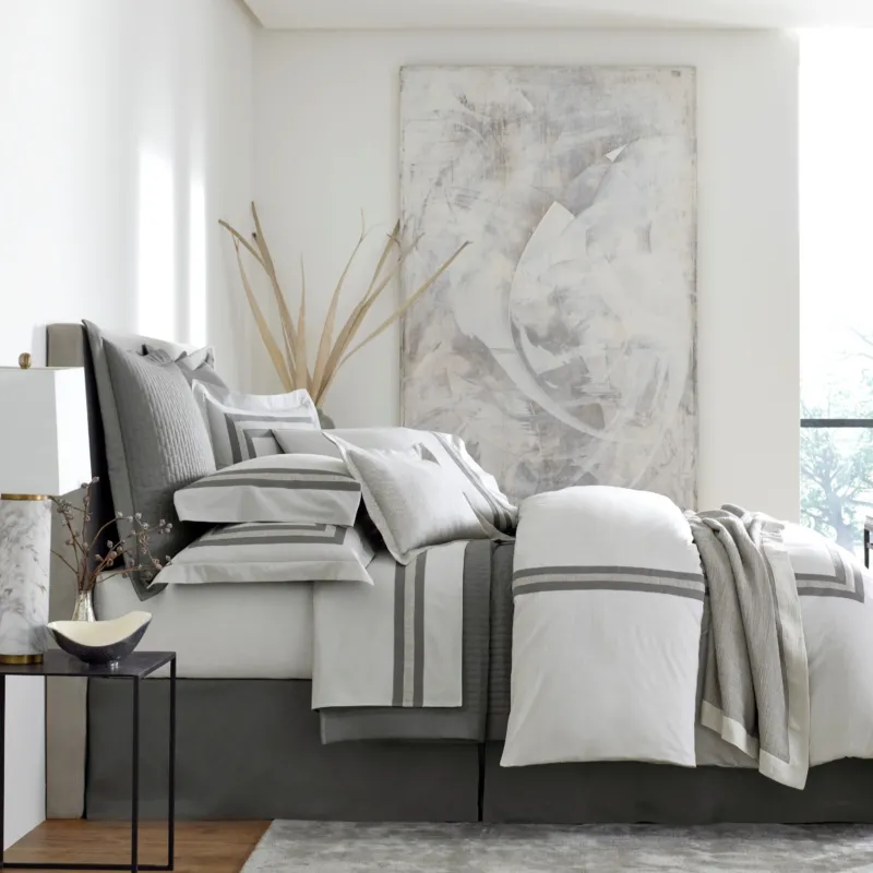 Home Treasures Harper quilted coverlet and euro shams in dove grey on a styled bed.